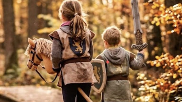 Kinder mit Steckenpferden im goldenen Herbstwald